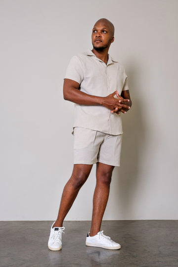 Beige Men’s Cuban Short Sleeve Shirt  showcasing Cuban collar, button-up front, short sleeves, and curved hem. High-quality fabric with a structured yet relaxed fit