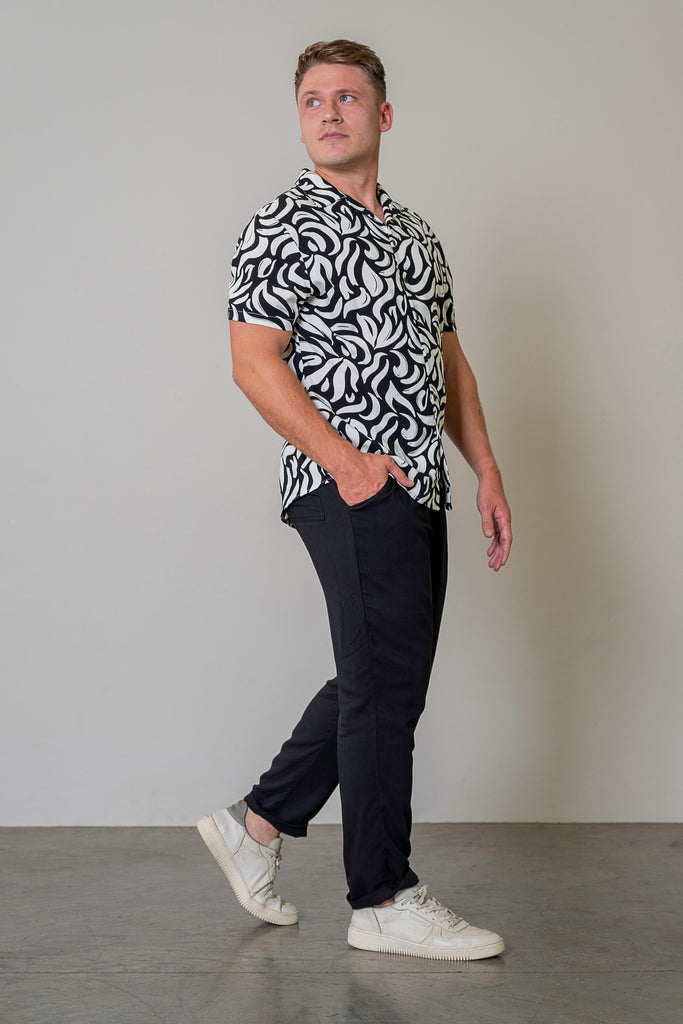 Black Cuban Short Sleeve Shirt for men with white geometric print, button-up front, Cuban collar, short sleeves, and curved hem. Smart casual summer shirt, lightweight and breathable fabric.