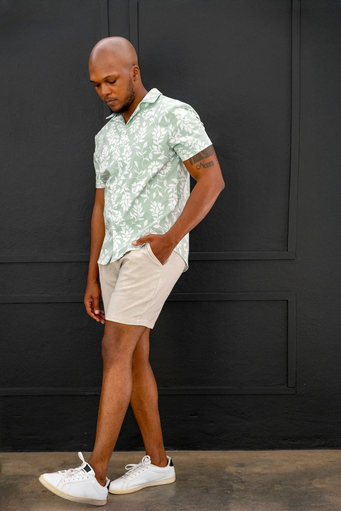Close-up of the Men’s Cuban Short Sleeve Shirt in Sage, highlighting the crisp Cuban collar, button details, and premium lightweight fabric with an Leave white pattern.