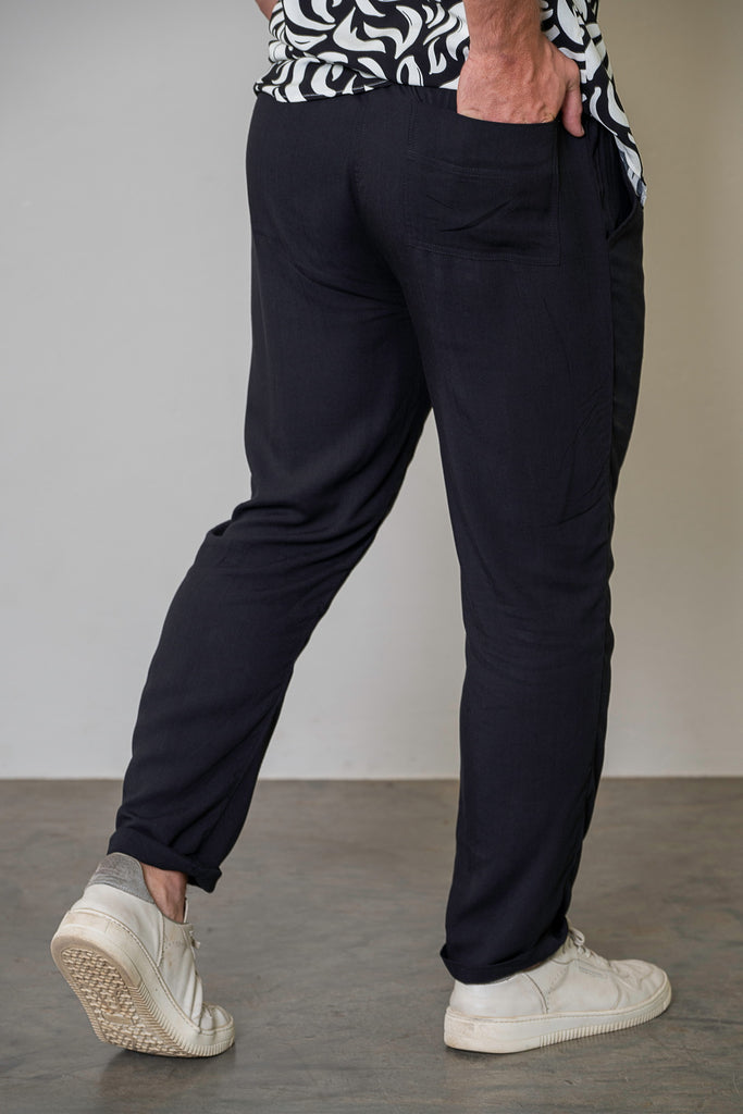 Back View (If Available)
"Back view of men’s lightweight black tailored trousers, featuring an elastic waistband, a single back pocket, and structured pleats for a modern, versatile look."