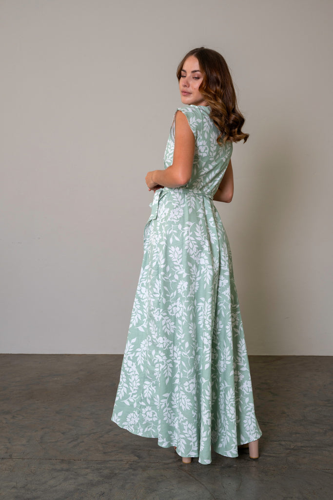 Maxi length wrap dress in a sage green with a waist tie and flattering silhouette. back view